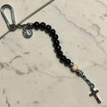 Saint Benedict decade rosary with black wood beads, white Our Father bead, black and white paracord, carabiner, medal, and crucifix