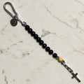 Saint Benedict decade rosary with black wood beads, beige Our Father bead, black and white paracord, carabiner, medal, and crucifix