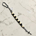 Saint Benedict decade rosary with alternating black and ivory wood beads, ivory Our Father bead, black and white paracord, carabiner, medal, and crucifix