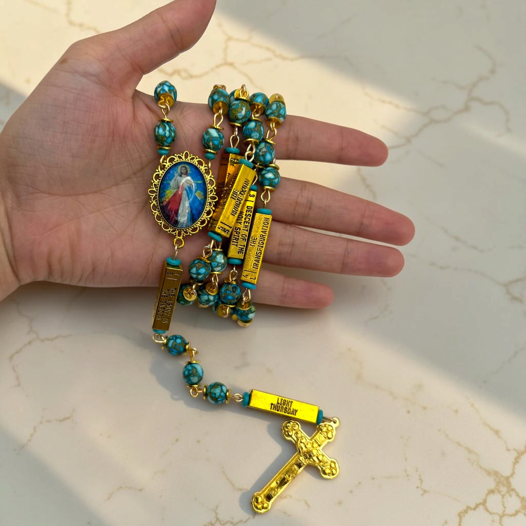 Hand-held gold and turquoise Divine Mercy guided mystery rosary with turquoise stone-look beads, gold mystery bars, Divine Mercy centerpiece, and gold crucifix