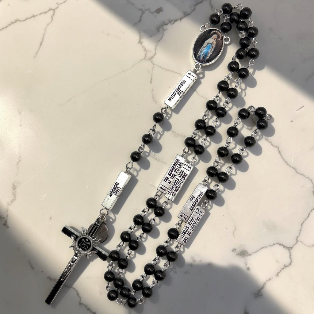 Full black and silver Guided Mystery Rosary with glossy black beads, engraved mystery bars, Our Lady of Lourdes centerpiece, and black-and-silver IHS crucifix