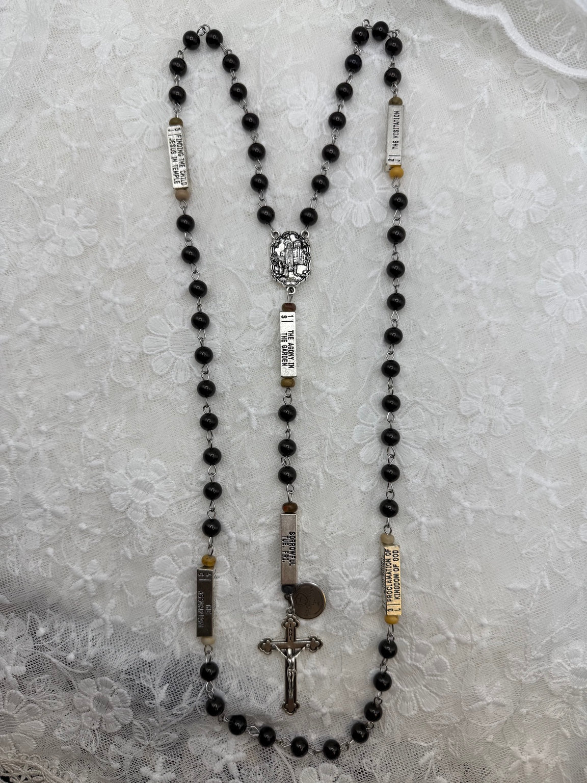 Full view of silver and black wood guided mystery rosary