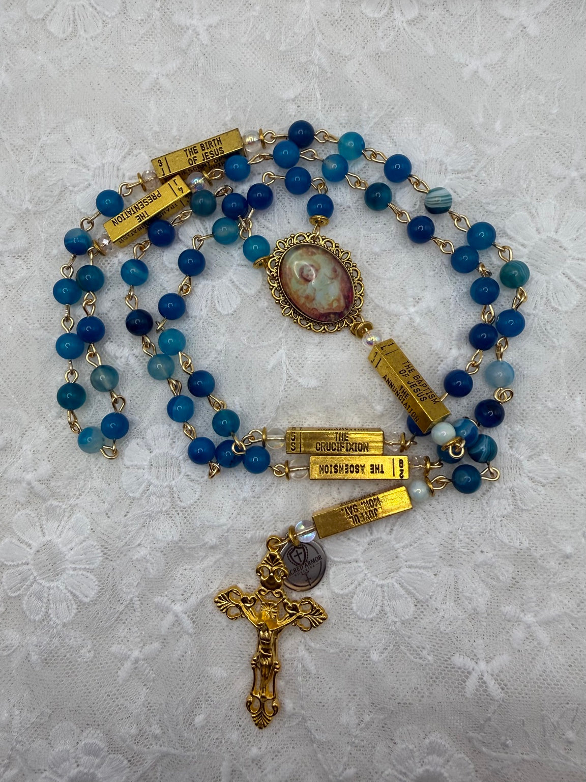 Blue agate beads and Baby Jesus centerpiece on white lace