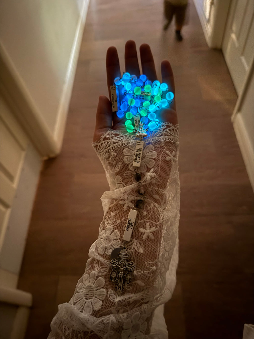 UV glow-in-the-dark rosary beads shining blue and green in low light