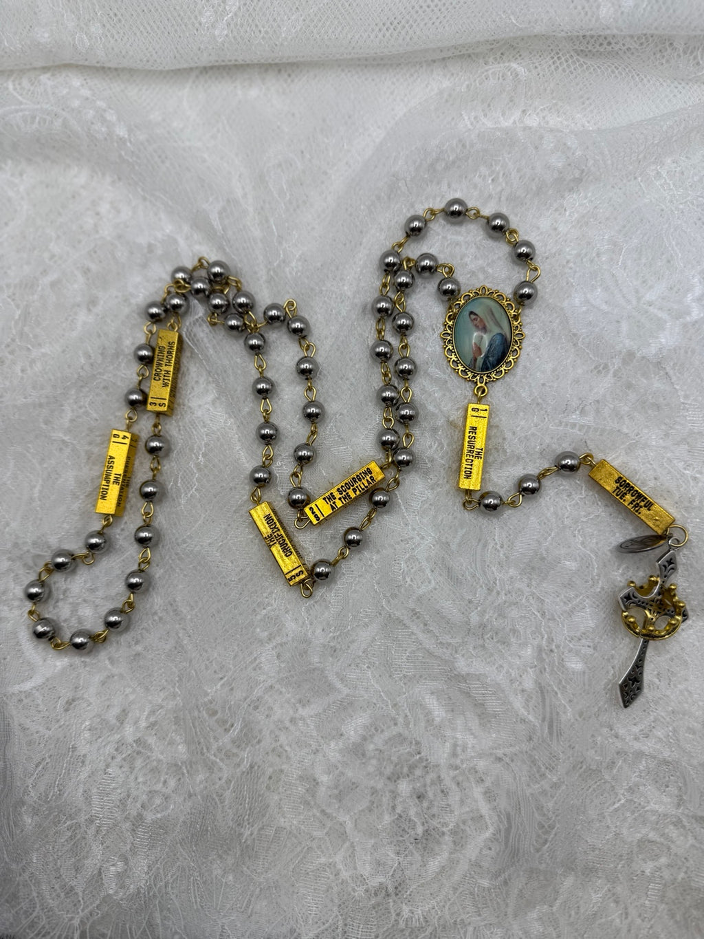 Full view of silver and gold Marian rosary with mystery bars