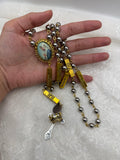 Close-up of silver and gold Marian rosary with hematite-style beads