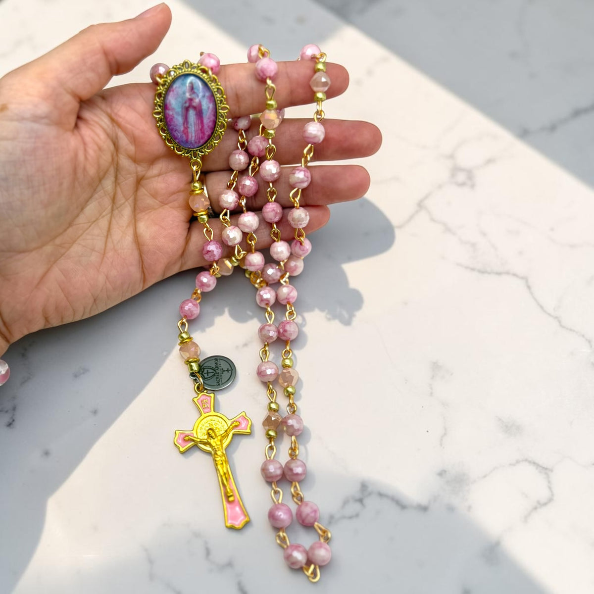 Rosa Mystica Chaplet held in hand for scale
