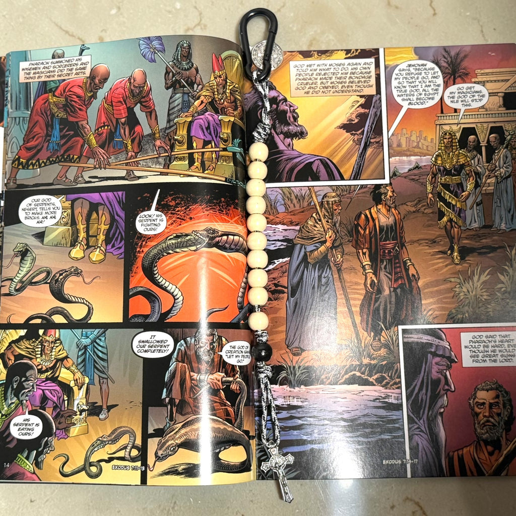 Moses comic book open to Exodus artwork with wooden St. Benedict decade rosary