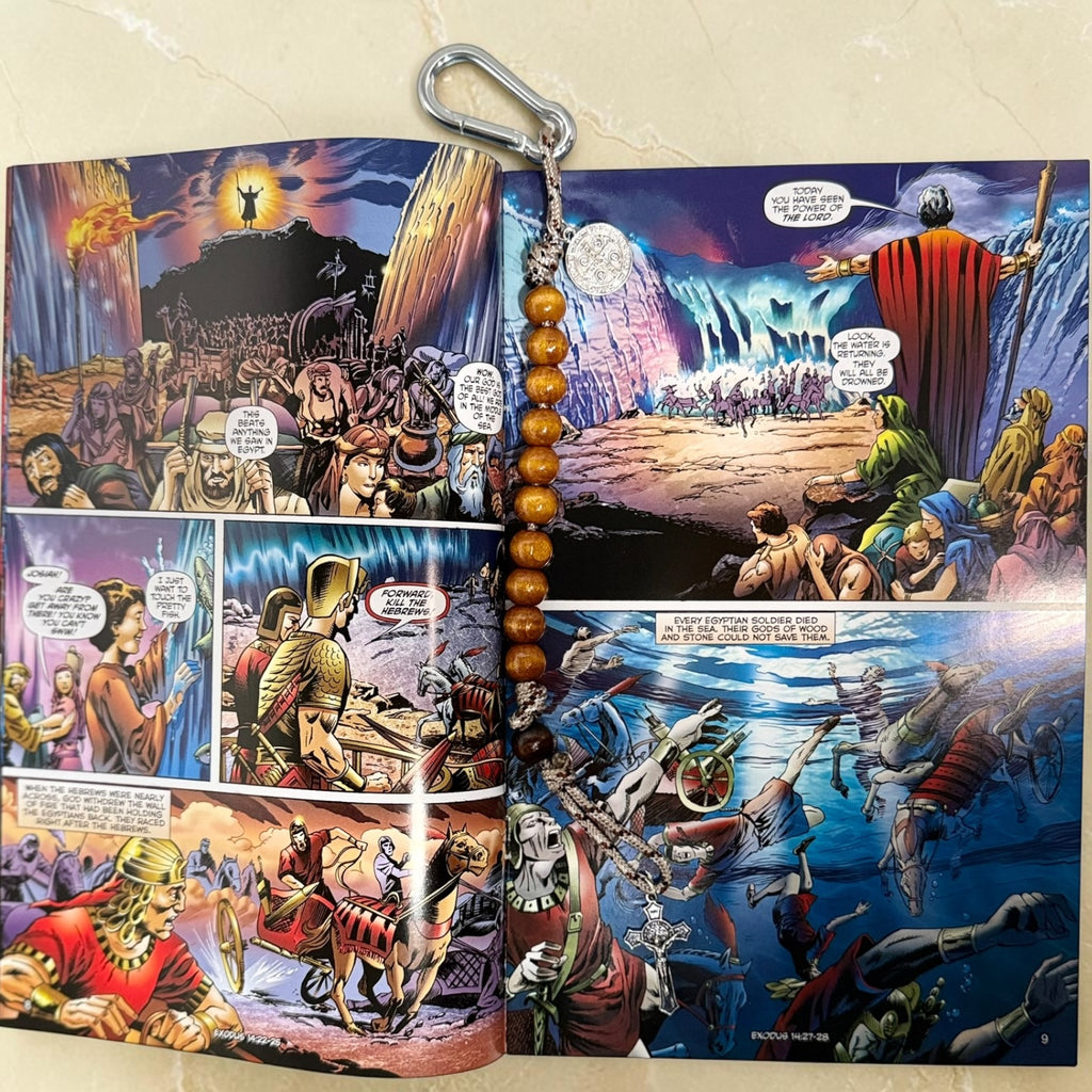 Exodus comic book open to Red Sea artwork with wooden St. Benedict decade rosary