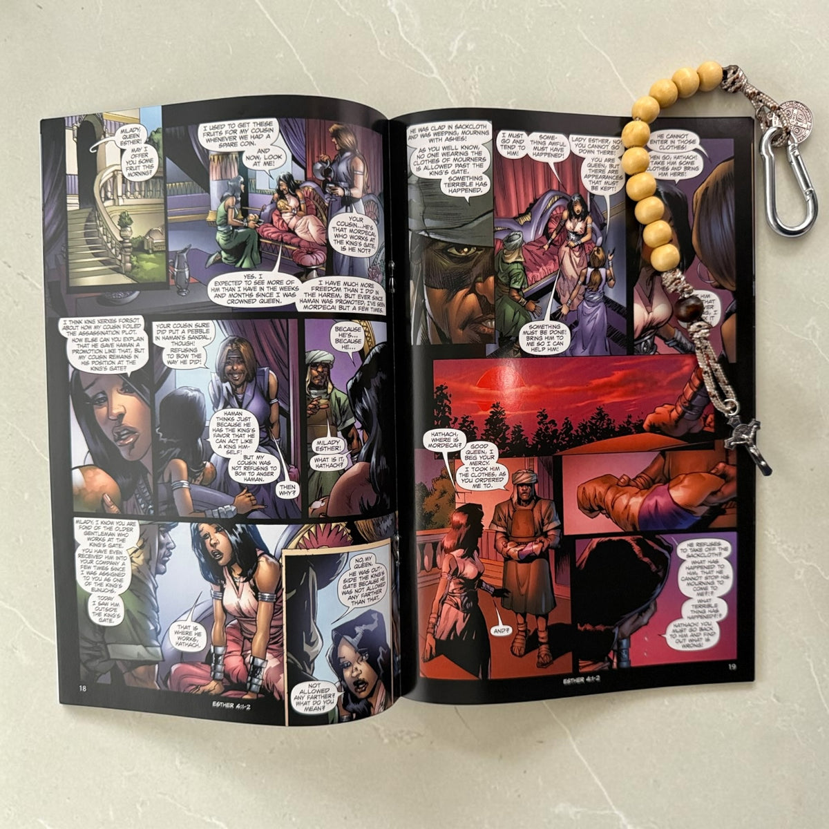 Esther comic book open to interior artwork with wooden St. Benedict decade rosary