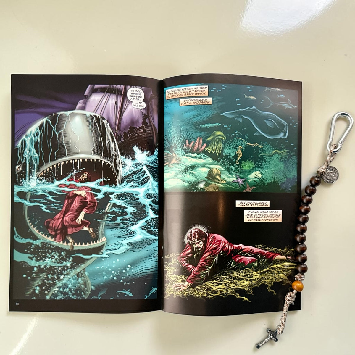 Jonah comic book open to interior artwork with wooden St. Benedict decade rosary