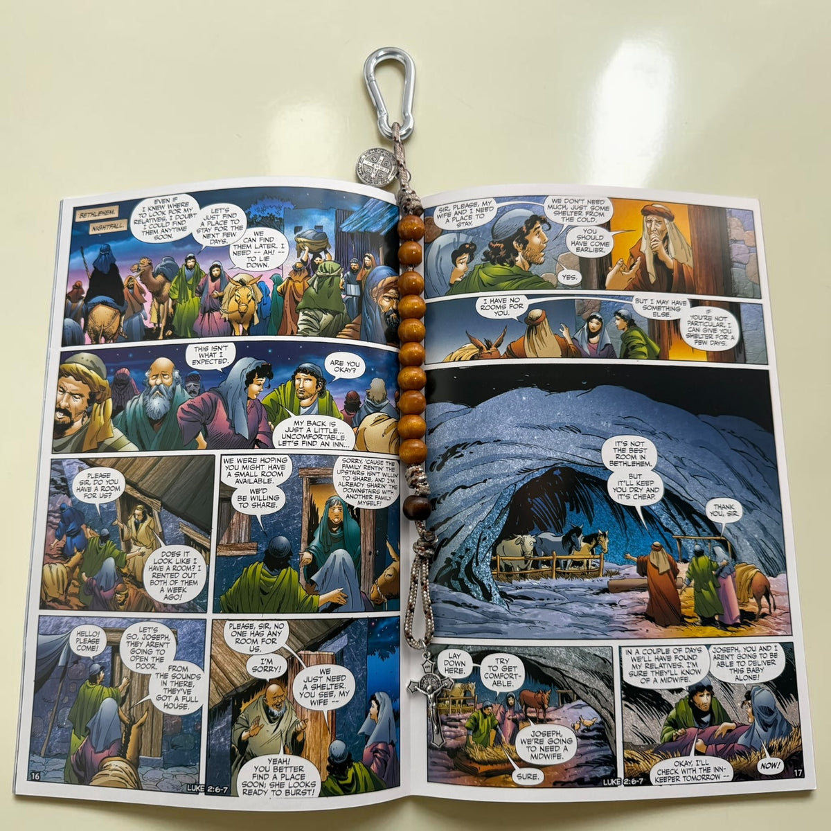 The Christ Volume 1 comic book open to Nativity artwork with wooden St. Benedict decade rosary