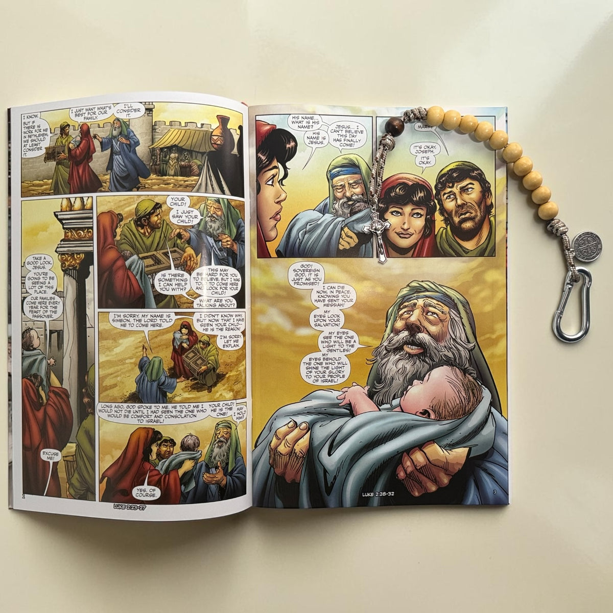 The Christ Volume 2 comic book open to childhood of Jesus artwork with wooden St. Benedict decade rosary