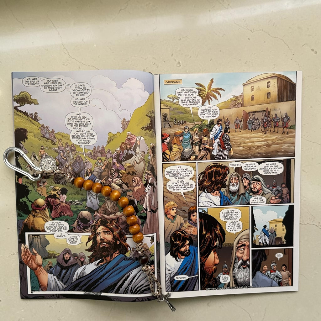 The Christ Volume 5 comic book open to the Sermon on the Mount with wooden St. Benedict decade rosary