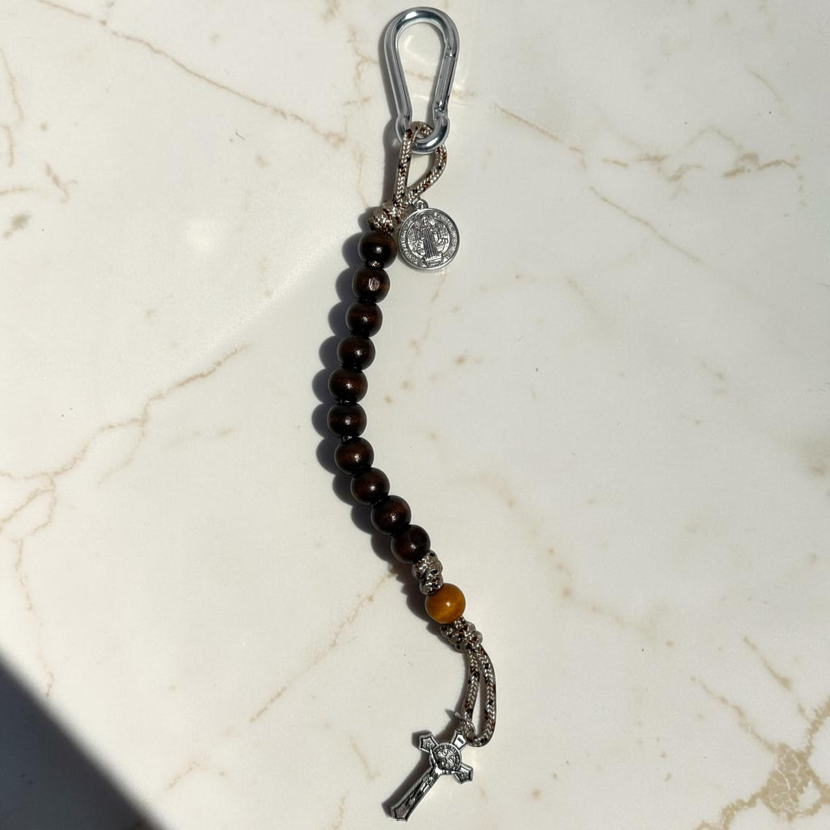 Saint Benedict decade rosary with desert camo paracord, dark wood beads, silver carabiner, medal, and crucifix