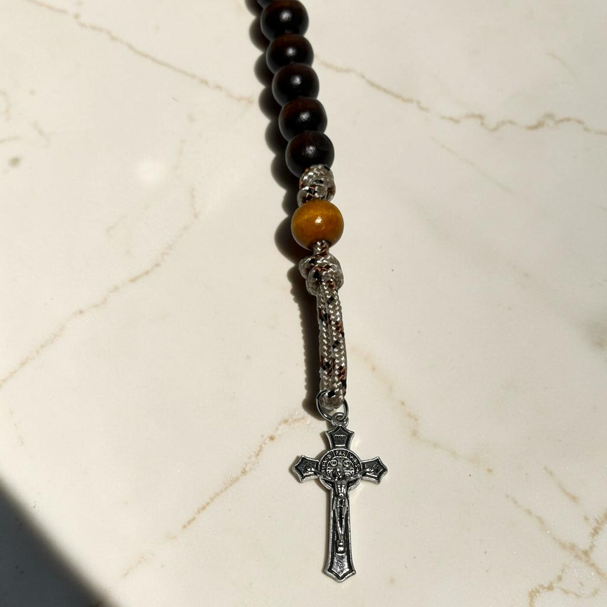 Close-up of desert camo paracord and Saint Benedict crucifix on handmade decade rosary