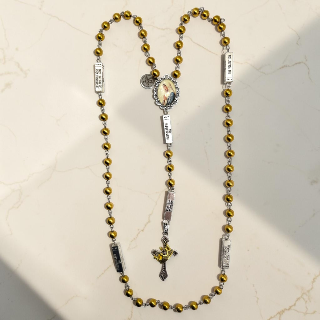 Silver and gold guided mystery rosary with gold beads, silver mystery plaques, Marian centerpiece, and crown crucifix