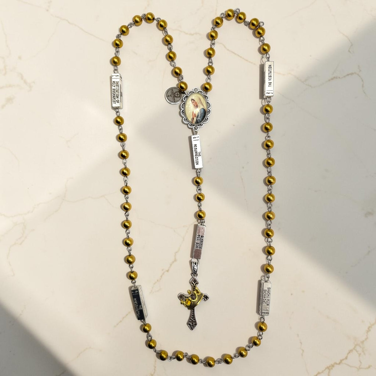 Silver and gold guided mystery rosary with gold beads, silver mystery plaques, Marian centerpiece, and crown crucifix