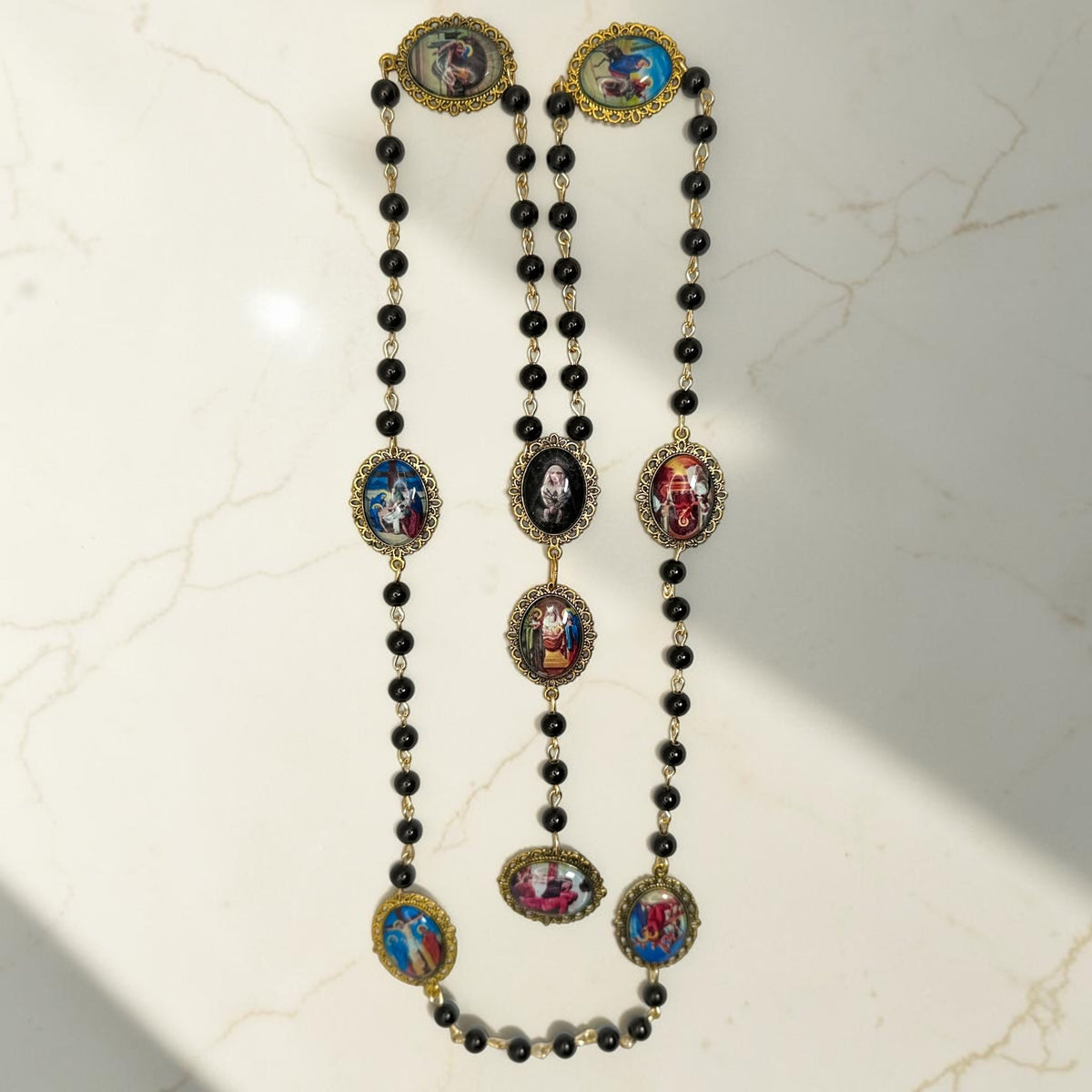 Full-length Our Lady of Sorrows chaplet with black beads and gold-tone framed meditation images