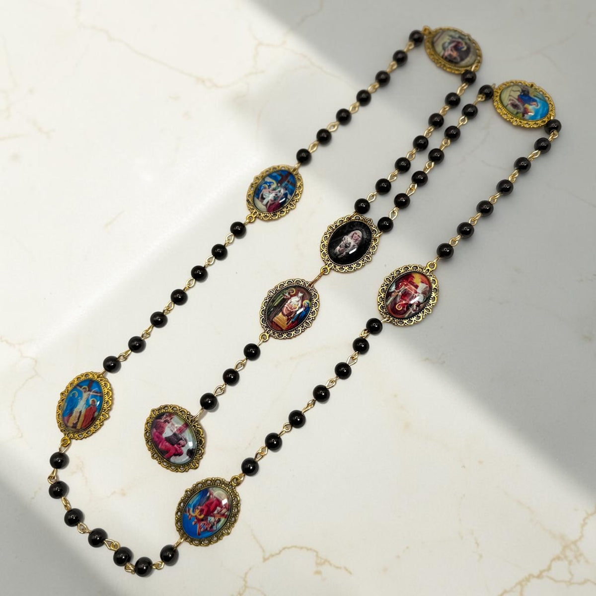 Our Lady of Sorrows chaplet arranged diagonally with black beads and cabochon meditation images