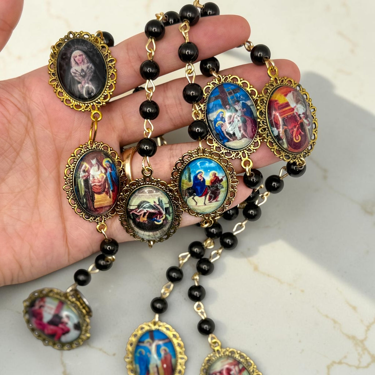 Close-up handheld view of Our Lady of Sorrows chaplet cabochon glass meditation beads