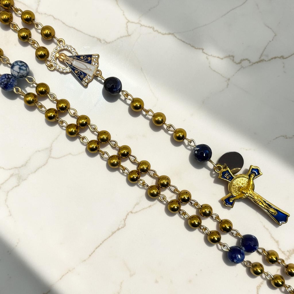 Close-up of Our Lady Aparecida centerpiece and gold-and-blue crucifix on handmade rosary