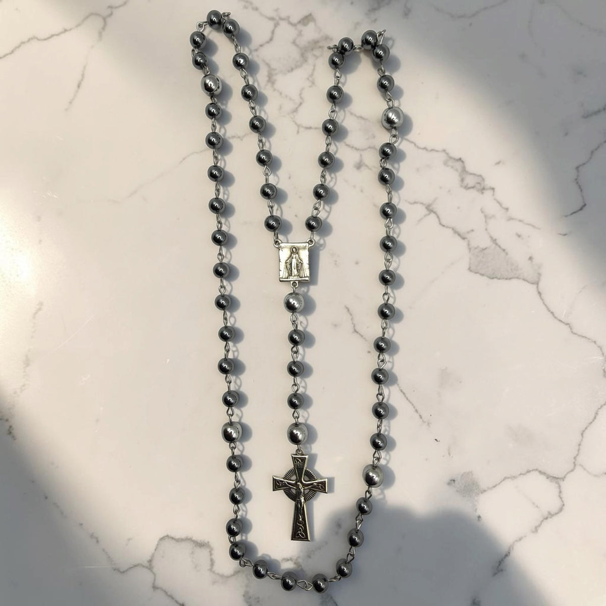 Dark gray hematite Miraculous Medal rosary with silver-tone chain, larger silver Our Father beads, Marian centerpiece, and ornate silver crucifix