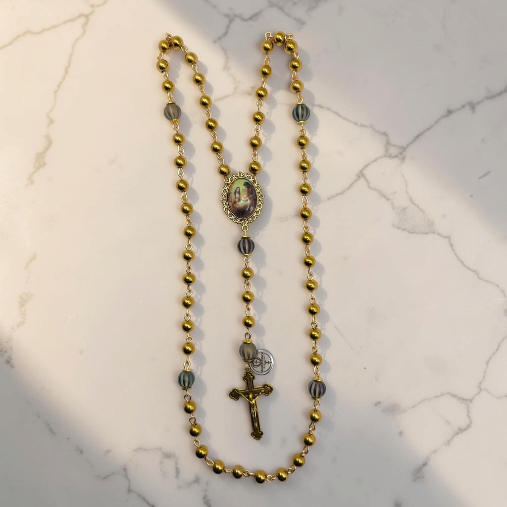 Full gold Holy Family rosary with polished gold-tone beads, striped accent Our Father beads, Holy Family centerpiece, and gold crucifix