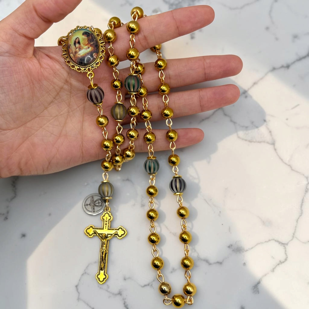 Hand-held gold Holy Family rosary with gold-tone beads, striped accent Our Father beads, Holy Family centerpiece, Sacred Armor medal, and gold crucifix