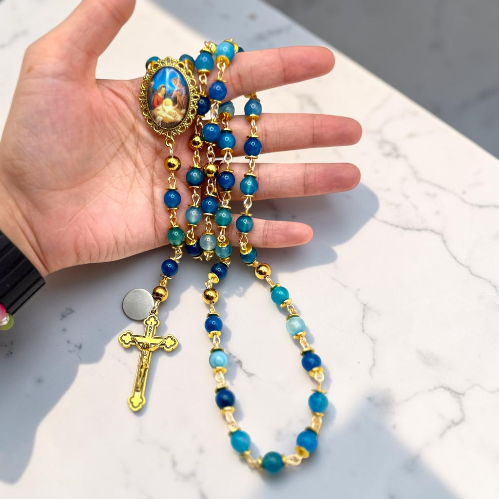 Blue striped agate and gold Holy Night rosary shown in hand