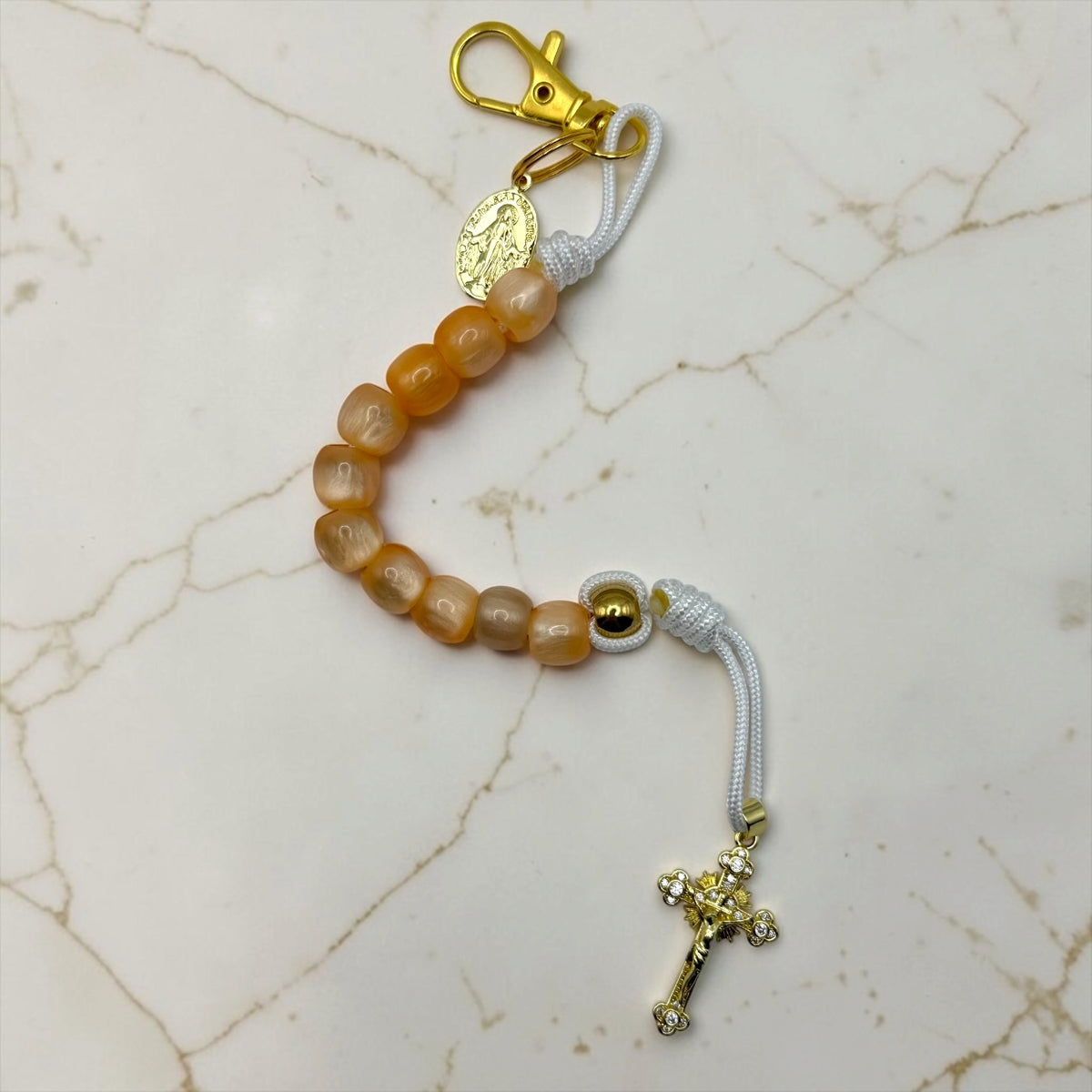 Handmade Catholic decade rosary with warm orange beads, white cord, gold crucifix and medal
