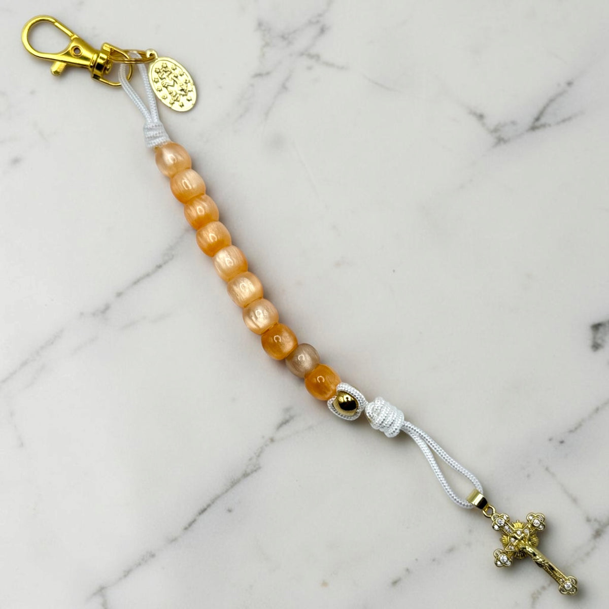 Portable Catholic decade rosary with orange beads, white cord, gold crucifix and clasp