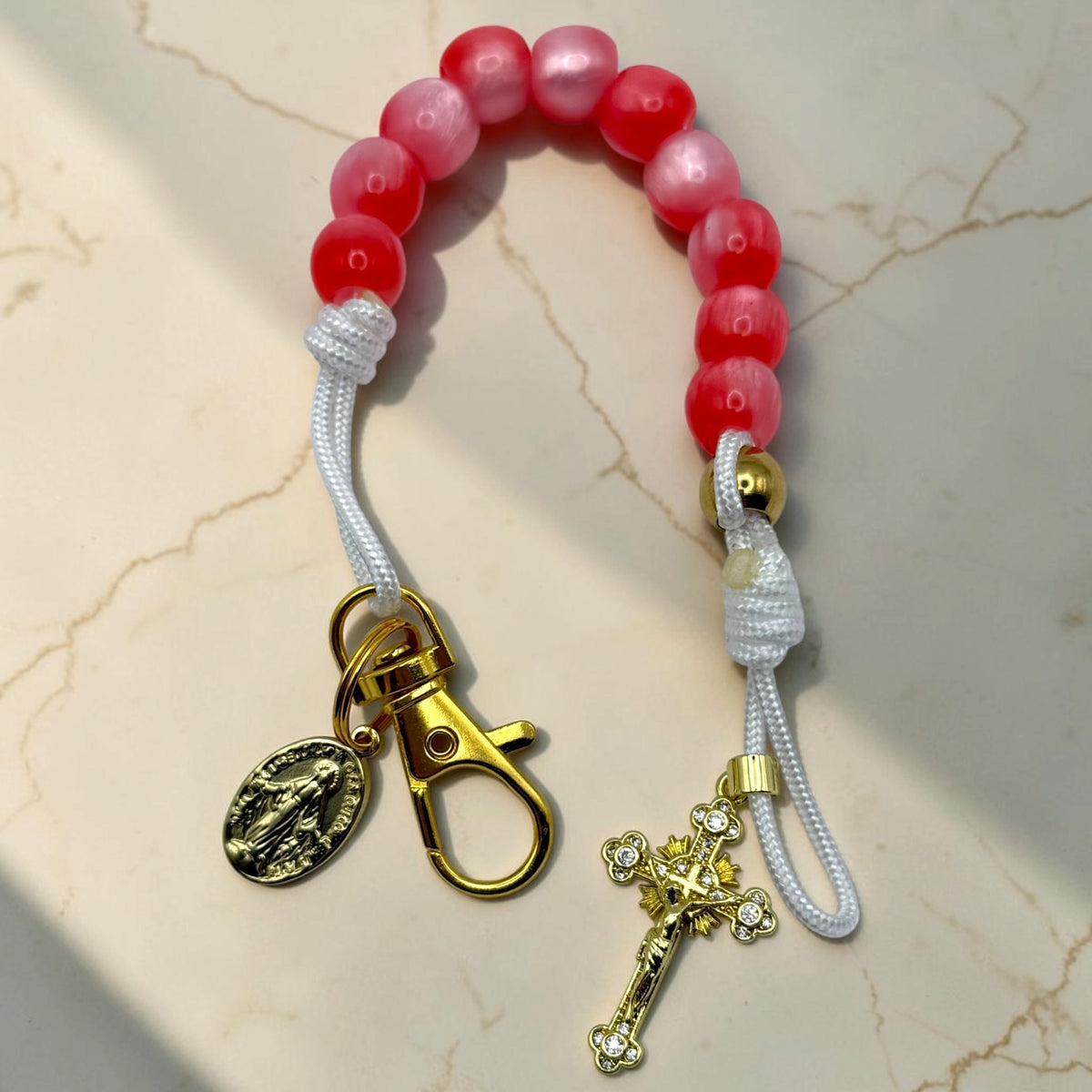 Handmade pink and red decade rosary with white cord, gold-tone clasp, Marian medal, and crystal-accented crucifix
