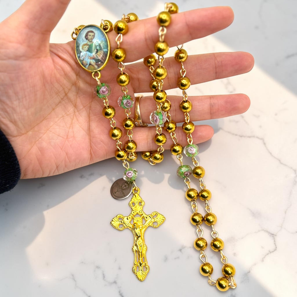 Gold Saint Joseph rosary shown in hand