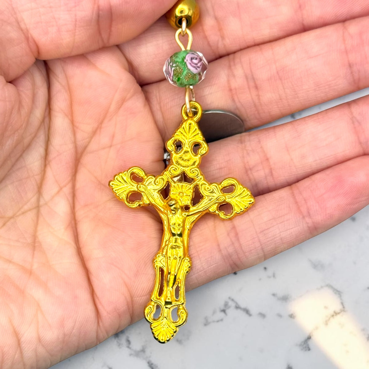 Gold Saint Joseph rosary crucifix and floral bead close-up
