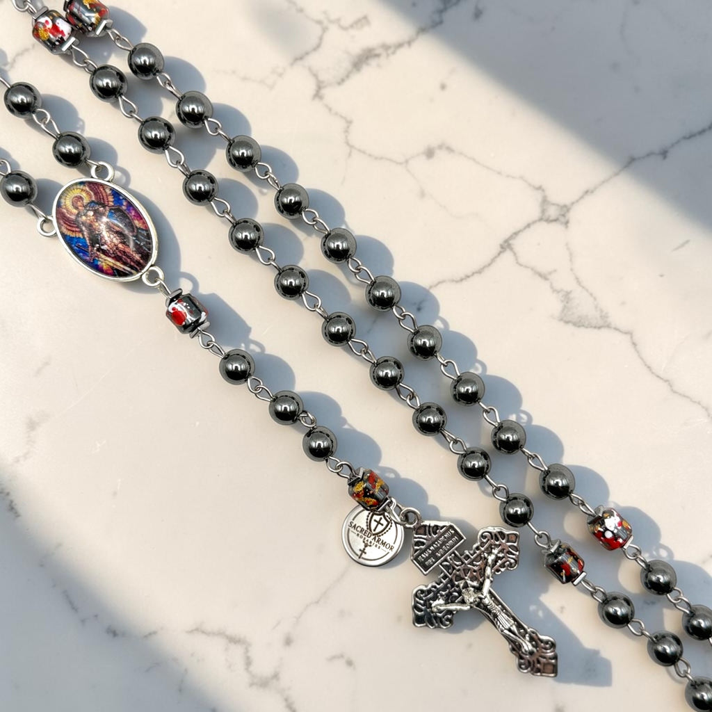 Saint Michael hematite rosary close-up with paint splatter accent beads