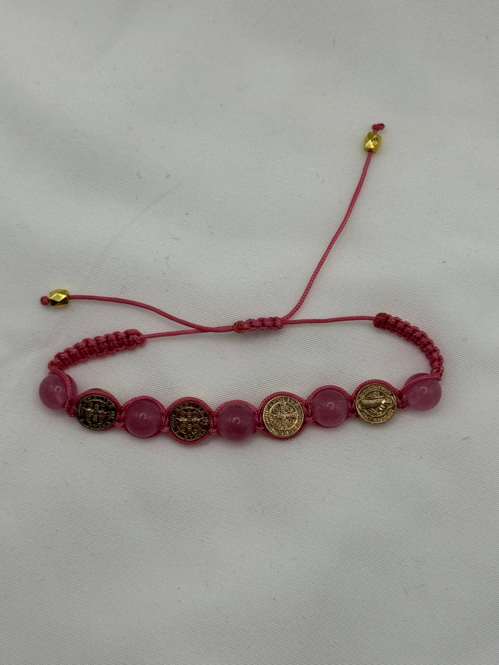 Adjustable pink cord Catholic bracelet with translucent pink beads and gold Saint Benedict medals
