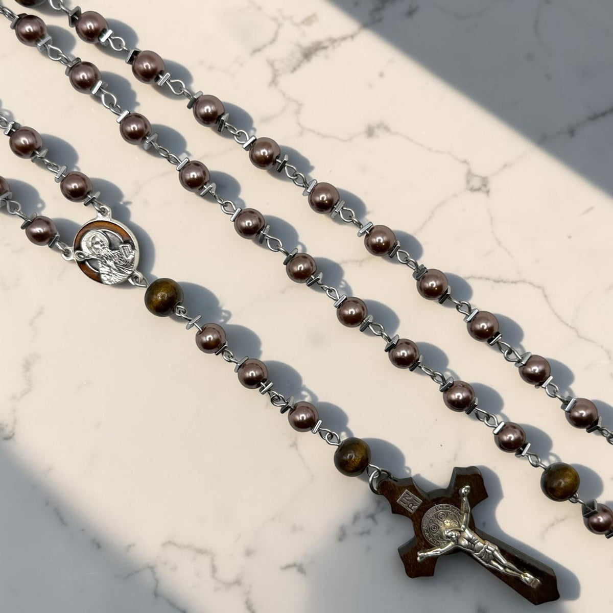 Purple pearl Saint Benedict rosary with wooden crucifix close-up