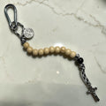 White wood and black St. Benedict pocket decade rosary with silver-tone carabiner and black-white paracord