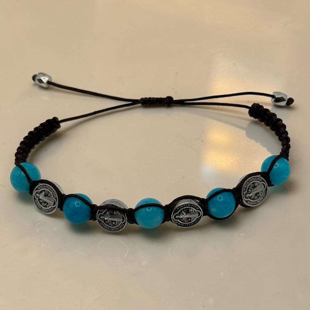 Turquoise-blue bead Saint Benedict medal bracelet with dark cord, front view